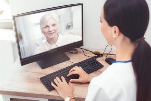 A medical provider doing a virtual session with a client on a computer
