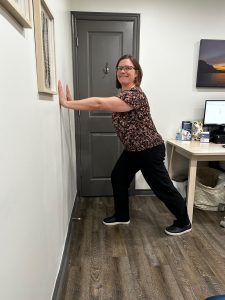 Christine Campbell, Physiotherapist, performing calf stretch by wall