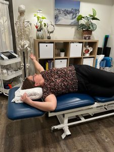 Christine Campbell, Physiotherapist, laying on side performing thoracic twist