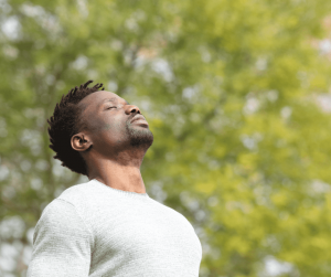 Man breathing, trees in background