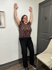 Christine Campbell, Physiotherapist, demonstrating exercise on wall