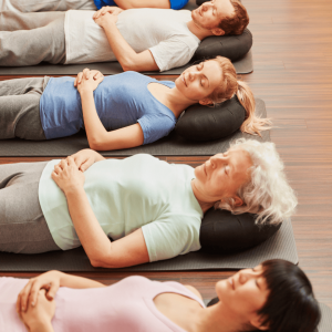 4 people laying on their backs practising breathing 