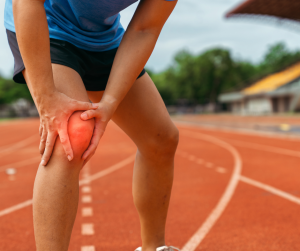 Person outside in shorts, holding their right knee