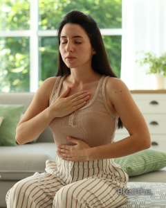 Women sitting with one hand on chest and one hand on belly