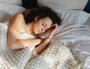Women sleeping on her side, in bed